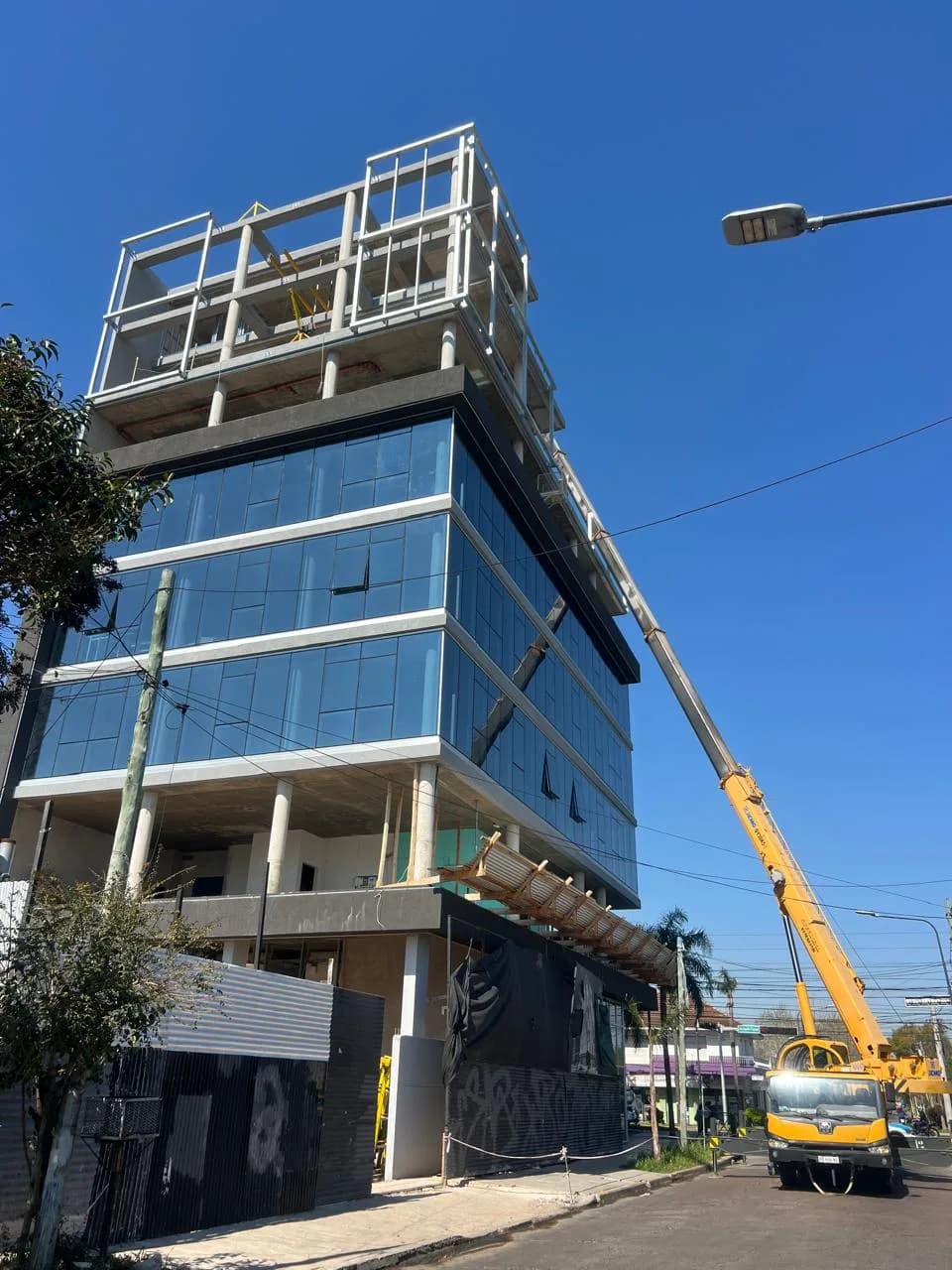 Avance de obra de Green Office — vista lateral con la grúa subiendo el coating wall